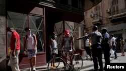 Un policía organiza una cola para comprar alimentos en La Habana. REUTERS/Alexandre Meneghini/File Photo