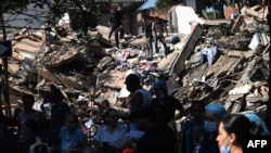 Pobladores buscan sobrevivientes entre los escombros de un edificio colapsado en Cali, tras el terremoto que sacudió Colombia este lunes.