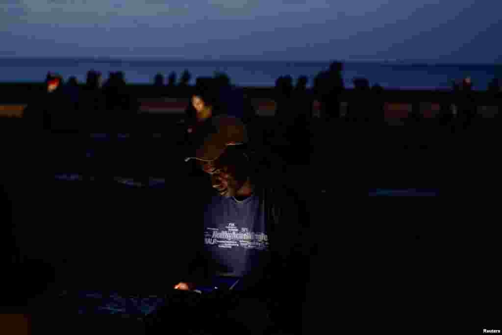 Un hombre revisa su teléfono en un parque mientras colapsaba la red eléctrica nacional de Cuba —lo que supuso el tercer apagón importante en nueve días— en La Habana, Cuba, el 14 de julio de 2026. REUTERS/Norlys Perez