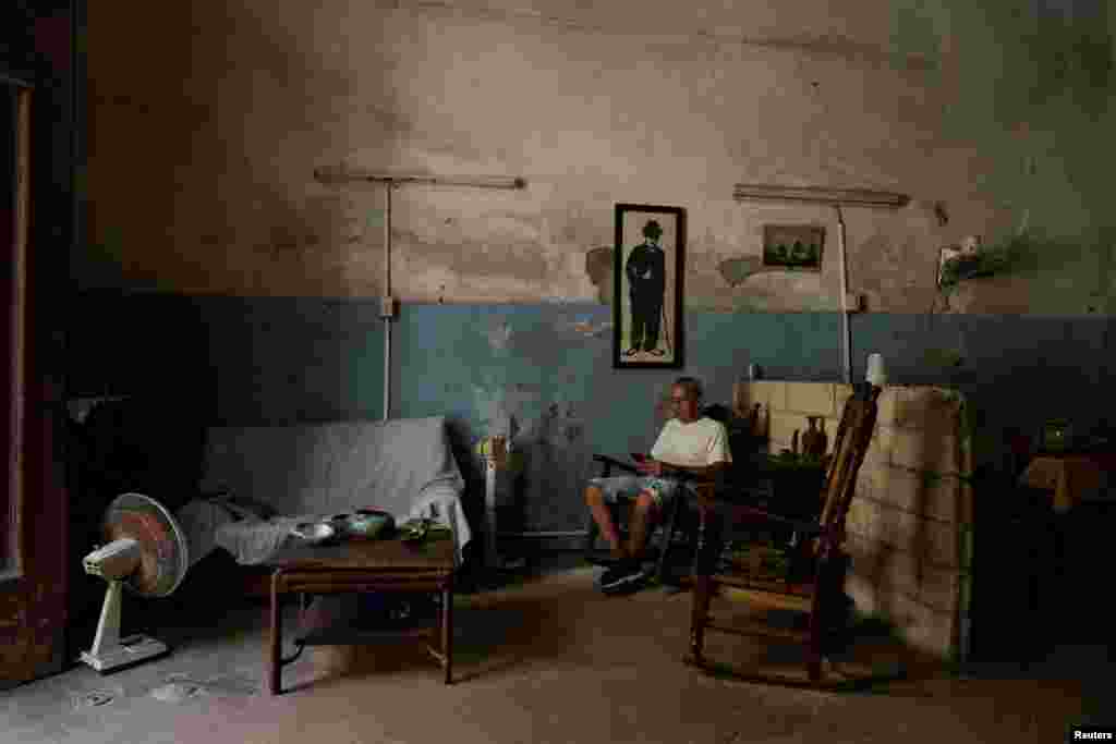Fernando Pérez revisa su teléfono en casa durante un apagón generalizado tras el colapso de la red eléctrica nacional de Cuba —el tercer gran corte de suministro en nueve días—, en La Habana, Cuba, el 14 de julio de 2026. REUTERS/Norlys Pérez