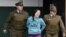 Integrantes de la policía chilena escoltan a Natalie Casanova Muñoz  hasta un Centro de justicia en Santiago de Chile.