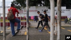 Migrantes caminan afuera del Instituto Nacional de Migración en Tapachula, estado de Chiapas, México. (Foto AP/Marco Ugarte)