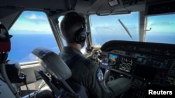 Un miembro de la Guardia Costera de los Estados Unidos pilota un avión HC-144 Ocean Sentry durante una misión de patrullaje en el Estrecho de Florida, el 17 de julio de 2021. REUTERS / Marco Bello