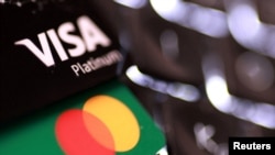 La ilustración muestra tarjetas de crédito Visa y Mastercard.