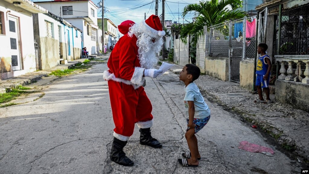 Un niño entrega una carta a Santa Claus, en La Habana, el 21 de diciembre de 2023.