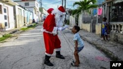 Un niño entrega una carta a Santa Claus, en La Habana, el 21 de diciembre de 2023.