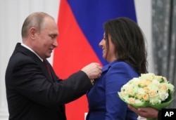 El presidente ruso Vladimir Putin otorga a Margarita Simonyan, directora del canal de televisión ruso RT, la Orden de Alexander Nevsky durante una ceremonia de premiación en el Kremlin en Moscú, Rusia, el jueves 23 de mayo de 2019.