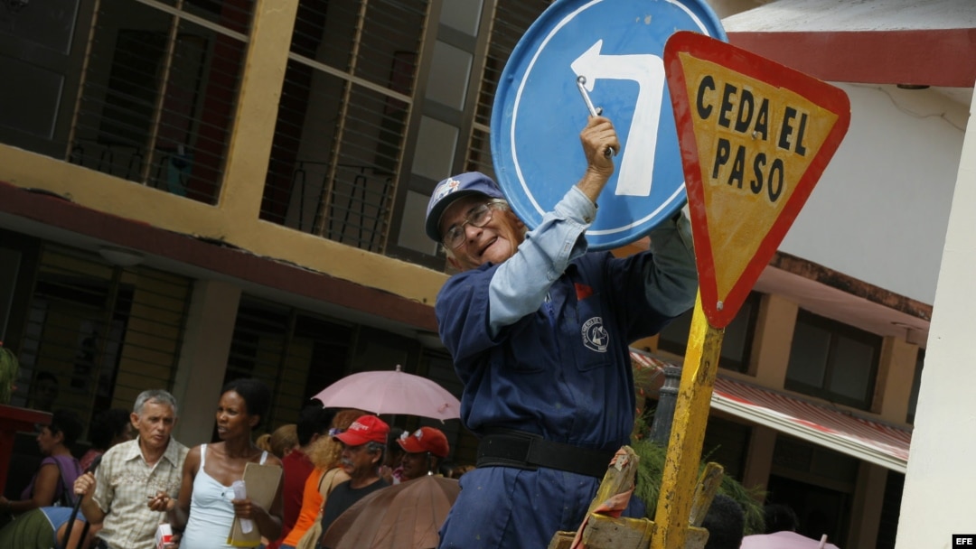 Un hombre instala una señal de tránsito en una calle de la Ciudad de Holguín (Cuba). 