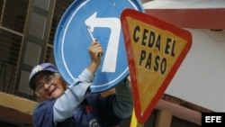 Un hombre instala una señal de tránsito en una calle de la Ciudad de Holguín (Cuba). 