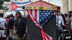 Un bicitaxi con la bandera estadounidense transporta turistas en La Habana. 