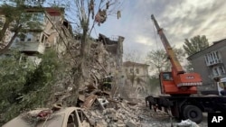 Rescatistas trabajan en el sitio en el edificio que fue impactado por ataques el6 de octubre de 2022, en Zaporiyia, Ucrania. (Servicio de Emergencias de Ucrania vía AP)