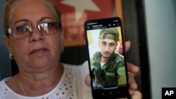 Marilin Vinent holds up a photo of her son Dannys Castillo, uno de los cubanos reclutados para luchar por Rusia en Ucrania. (Foto AP/Ramón Espinosa)