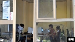 Varias personas consultan Internet en una "sala de navegación", perteneciente a la empresa estatal Correos de Cuba.