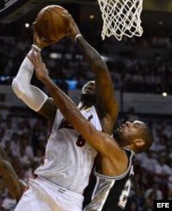 Tim Duncan de los Spurs trata de eevitar la canasta de LeBron James, capitán del Heat, en el 7mo partido de la final de la NBA 2013. (EFE)