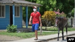 Un hombre se cubre con nasobuco el lunes en una calle de Bahía Honda, en la provincia de Artemisa (Yamil Lage/AFP).