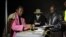 Miembros de la Comisión Electoral de Zimbabue observan mientras se sellan las cajas de votación tras el cierre de los colegios electorales en las elecciones de Zimbaue