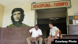 En Cuba dos jóvenes agentes de seguridad sentados bajo el lema revolucionario "Disciplina es triunfo" (Blog 3rd Culture Cafe).