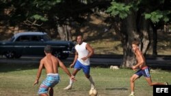 Jóvenes juegan fútbol en un parque de La Habana.