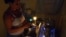 Una mujer prepara unos platos de comida en la cocina, iluminada con velas, durante un apagón en el barrio de Alamar.