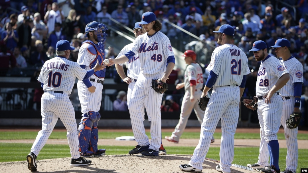 Entrenador de los Mets de NY Terry Collins (i) recibe la pelota del lanzador Jacob deGrom (c)