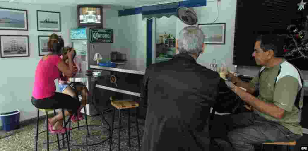  Varias personas observan la intervención del presidente cubano, Raúl Castro, en transmisión de la televisión cubana. 