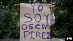 Una mujer sostiene un cartel en el que se lee "Yo soy Óscar Pérez" frente a la morgue donde permanece su cuerpo. 