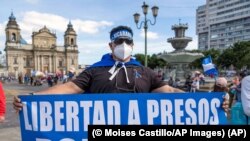 Un hombre nicaragüense sostiene un cartel que dice “Libertad a presos políticos” durante una protesta contra el gobierno Ortega-Murillo el 7 de noviembre en Ciudad de Guatemala. (AP Photo/Moises Castillo).