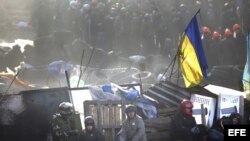 Manifestantes antigubernamentales pernoctan en una barricada la noche del jueves en Kiev.
