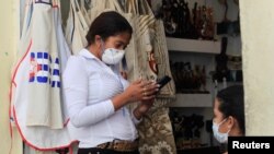 Una trabajadora de una tienda de La Habana se protege ante el avance del coronavirus en la isla.