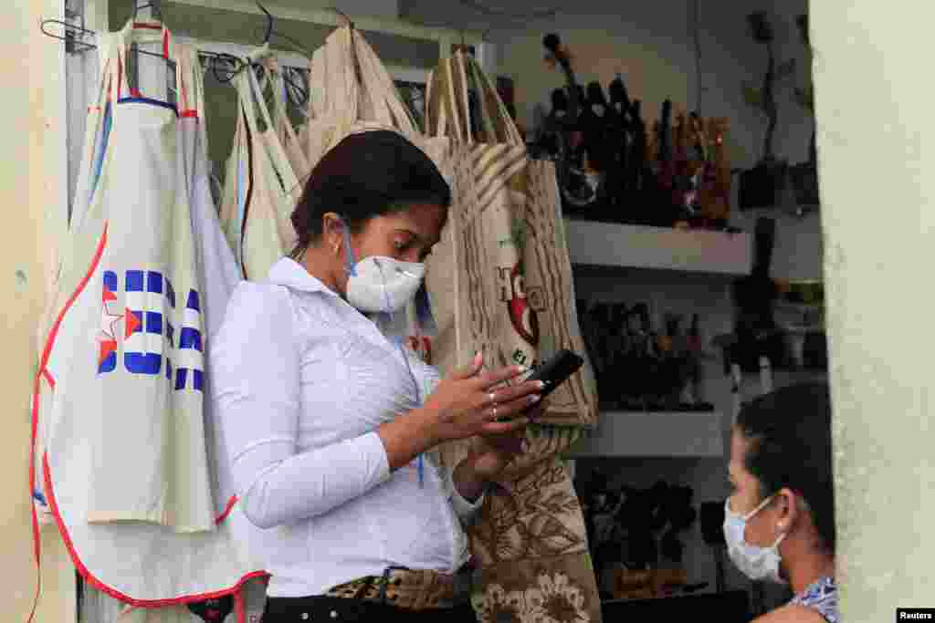 Una trabajadora de una tienda de souvenirs en La Habana se protege ante el avance del coronavirus en la isla.