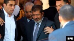 El presidente electo de Egipto, Mohamed Mursi (centro), abandona la mezquita de Al-Azhar en El Cairo