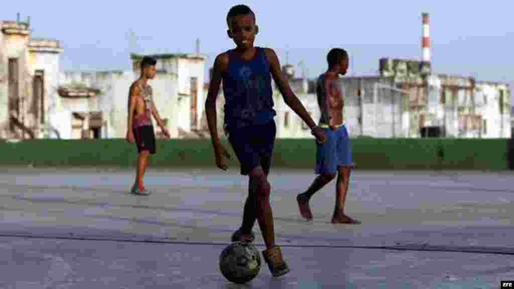 Jóvenes cubanos juegan fútbol donde encuentran espacio sin importar la escasez de zapatos o balones.