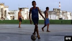 Jóvenes cubanos juegan fútbol donde encuentran espacio sin importar la escasez de zapatos o balones.