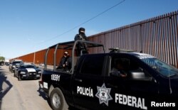 La policía mexicana vigila el muro durante la visita del presidente de EEUU, Donald Trump, a Calexico, California.
