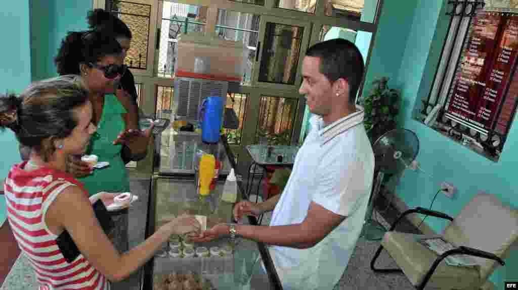 Dos mujeres son atendidas en una cafetería de un trabajador &quot;cuentapropista&quot; en La Habana (Cuba).