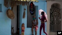 Habaneros con nasobuco para protegerse del coronavirus. Un rebrote de la enfermedad golpea a la capital cubana. (AP/Ismael Francisco)