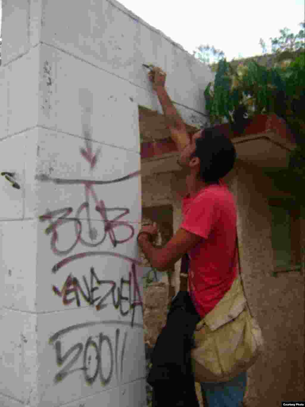 El grafitero cubano en plena acción callejera.