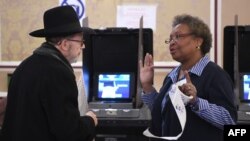 Un votante habla con una trabajadora de un colegio electoral de Nueva York después de depositar su voto en las elecciones de 2016 en EE.UU.