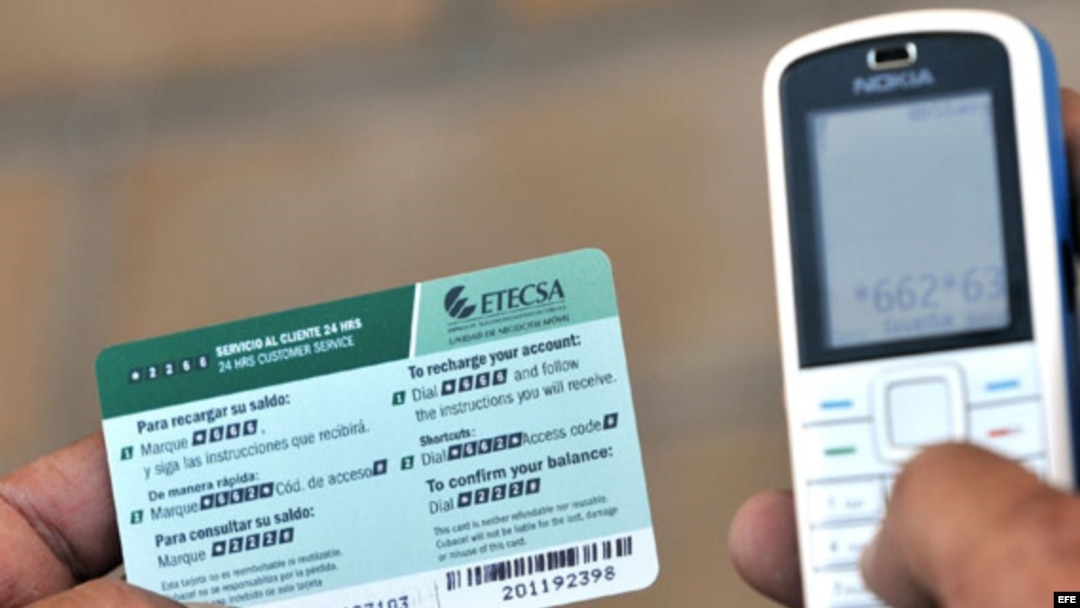 Un hombre recarga un teléfono celular con una tarjeta prepago de la empresa de Telecomunicaciones de Cuba (ETECSA), en La Habana.