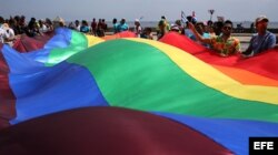 Cientos de personas ondean una gigante bandera de la comunidad LGBTI durante una "conga" contra la homofobia y la transfobia en La Habana.