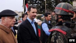 Fotografía enviada por la agencia de noticias siria (SANA) donde se muestra al presidente sirio Bashar Assad (C) en el barrio de baba Amr en Homs, Siria.