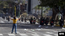 Manifestantes opositores se enfrentan este sábado a la Guardia Nacional Bolivariana.