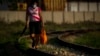 Una mujer camina con provisiones a lo largo de la línea del ferrocarril en una zona rural de La Habana. (AP/Ramón Espinosa)