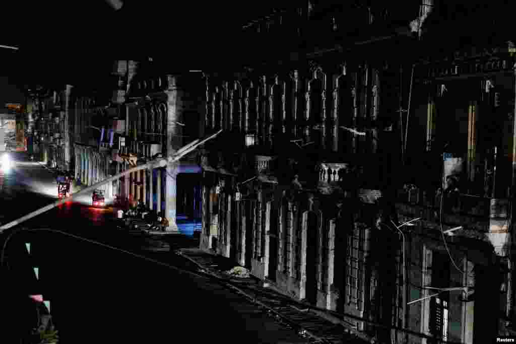Las fachadas de edificios de apartamentos son iluminadas por los faros de los vehículos tras el colapso de la red eléctrica nacional de Cuba —el tercer apagón importante en nueve días— en La Habana, Cuba, el 14 de julio de 2026. REUTERS/Norlys Perez