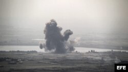 Fotografía que muestra una columna de humo causada por los enfrentamientos que tienen lugar entre la armada siria del presidente Bachar Al Assad y la armada de la oposición, cerca del pueblo sirio de Al-Rafide, 