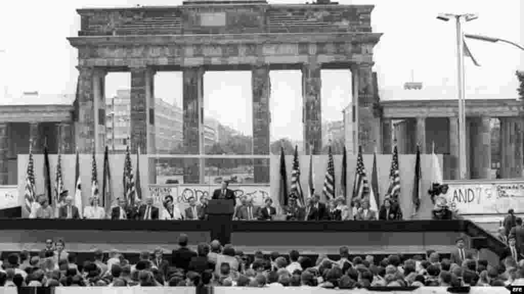 Fotografía de archivo del 12 de junio de 1987 que muestra al por entonces presidente de Estados Unidos Ronald Reagan (c) y al canciller alemán Helmut Kohl (a la derecha de Reagan) durante una ceremonia en el lado oeste del Muro de Berlín (Alemania), frente a la Puerta de Brandemburgo. Los berlineses gritaban: &quot;Sr. Gorbachov, ídestruya este muro!&quot;. Reagan viajó a Berlín para celebrar el 750&ordm; aniversario de la ciudad. La construcción de la barrera comenzó el 13 de agosto de 1961 y el muro cayó el 9 de noviembre de 1989. 