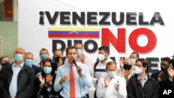 Flanqueado por colegas, el líder opositor venezolano Juan Guaidó habla durante una conferencia de prensa en Caracas un día después de las elecciones parlamentarias. Diciembre 7, 2020. Foto Archivo: AP/Ariana Cubillos.