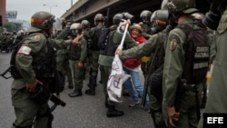 Militares retiran a una mujer que bloqueaba el paso de una tanqueta de la Guardia Nacional durante una manifestación.