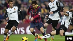 El delantero del FC Barcelona Lionel Messi con el balón ante los jugadores del Valencia