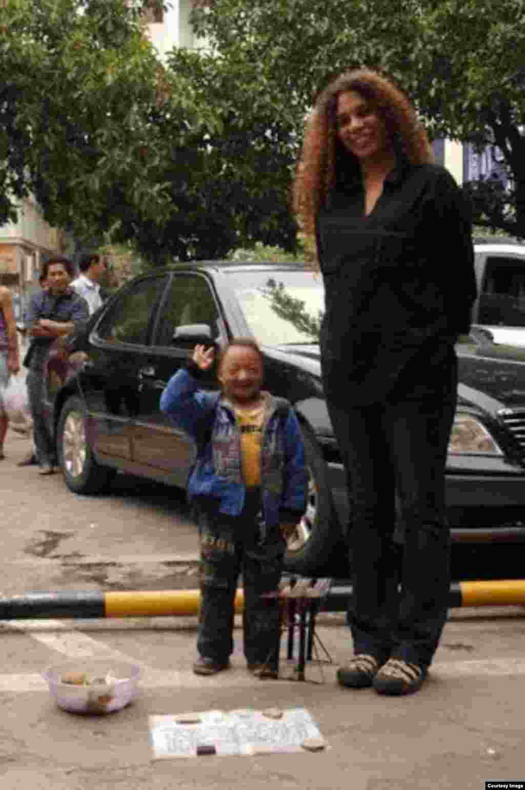 Niurka Seyfert Fernández, junto al hombre más pequeño de China. Foto cortesía de NSF.